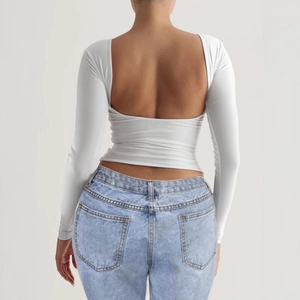 Slim fit white long sleeve Y2K top for women featuring a stylish open back design