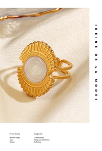 Détail d'une bague éventail dorée rétro avec incrustation blanche sur soie élégante
