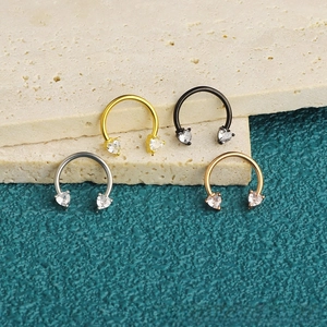 Close-up of C-shaped stainless steel nose rings with heart zircon in four metallic colors