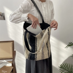 Detail of large striped tote bag showing spacious interior with books for commuting