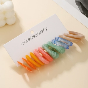 Detail of colorful resin C-shape hoop earrings set on professional display card