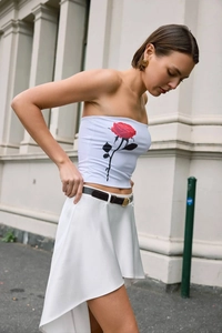 Detail of white cropped tube top featuring a vibrant red rose floral print design