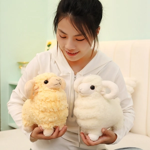 Cute plush sheep toys in cream and white colors held by a model in a cozy bedroom