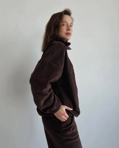 Détail de la texture polaire marron chaud sur l'ensemble sweat demi-zip et pantalon