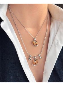 Détail d'un collier argenté à deux rangs avec cheval en bois et breloques coeur