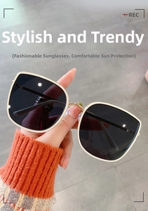 Detail of cream white oversized square sunglasses with gold metal hinges and dark lenses