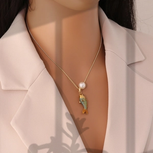 Détail du pendentif carpe koï en émail doré avec perle sur chaîne en acier inoxydable
