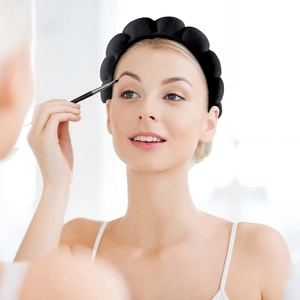Close-up of a black padded sponge headband worn by a woman during a makeup routine