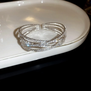 Close-up of silver-tone crisscross bangle with sparkling rhinestones and pearls