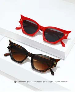 Detail of red and tortoiseshell cat-eye sunglasses with unique sharp temple tips and gold logo