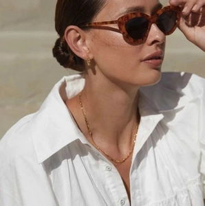 Elegant 18K gold plated twisted hoop earrings with a gold chain and tortoiseshell sunglasses