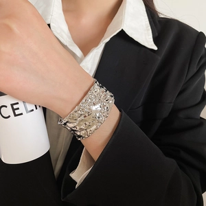 Detailed view of silver metallic textured flower open cuff bracelet with hammered finish