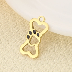 Close-up of golden dog bone pendant with black enamel paw print and heart cutout