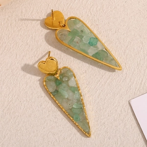 Detail of 18K gold heart stud earrings with inlaid green and white crushed stones