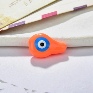 Macro view of orange resin evil eye charm bead for DIY jewelry making and crafting