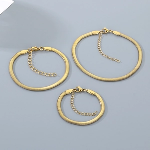 Flat lay of three golden stainless steel snake chains with lobster clasps on gray background