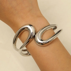 Detail of silver irregular double-ring bangle with mirror finish on female wrist