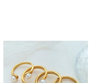 Detailed view of four minimalist gold-finish open rings featuring elegant white pearls