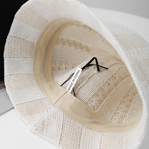 Detail view of cream knit bucket hat interior with sweatband and adjustable drawstring