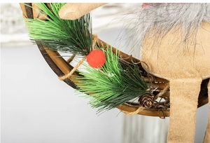 Close-up of Christmas wreath showing green pine needles, rattan base and red felt deer