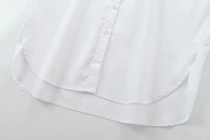 Détail de l'ourlet d'une chemise blanche en coton avec coutures et coupe arrondie