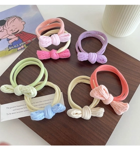 Detailed view of colorful corduroy bow scrunchies set displayed on a wooden tray