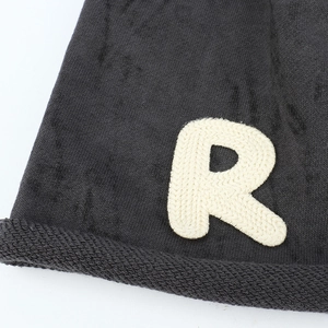 Bonnet en tricot noir avec bord roulé et broderie blanche de la lettre R