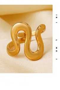 Macro detail of gold wavy irregular ring on beige silk with high mirror polish finish