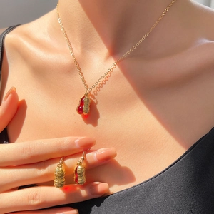 Schickes Schmuckset in Gold und Rot mit Halskette und passenden Ohrringen an Model