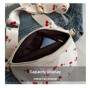 Detail view of white cherry print fanny pack showing interior capacity and zip pocket