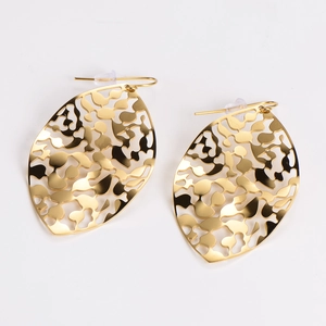Detail of golden hollow leaf earrings with textured pattern on white background