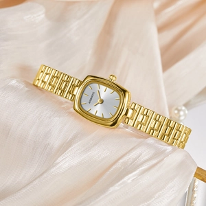 Montre vintage dorée élégante avec cadran argenté sur fond en soie beige chic
