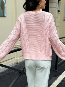 Detailed back view of pink knit sweater with intricate cable texture and cutout design