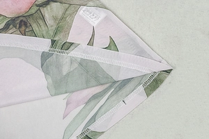 Detail of high-quality hem stitching and care label on tropical floral print dress