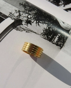Künstlerische Nahaufnahme des 18K vergoldeten breiten Rings auf einer Modezeitschrift