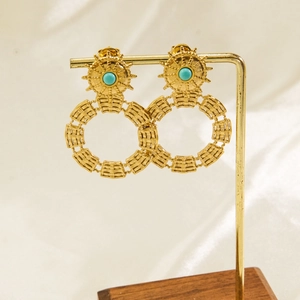 Detail of vintage gold earrings with turquoise stone on a metal display stand