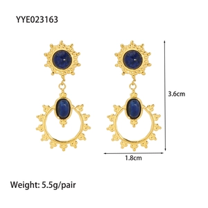 Détail de boucles d'oreilles vintage en acier doré avec lapis-lazuli et soleil