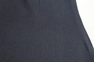 Close-up of high-quality black knitted fabric texture showing material density and weave