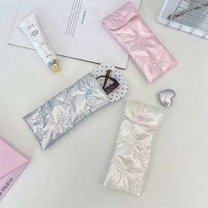 Detailed view of PU leather bow embossed sunglasses pouches in pink, silver and white