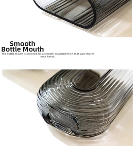 Close-up of the smooth polished rim and ribbed texture on the smoky grey glass vase