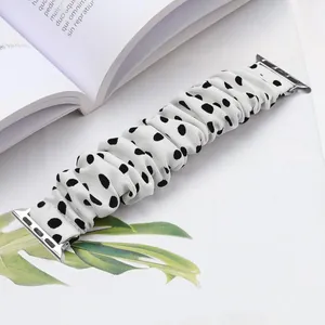Close-up of stylish white scrunchie watch band with black polka dots and metal connectors