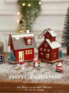 Close-up of LED wooden Christmas house with snow details and warm festive glow