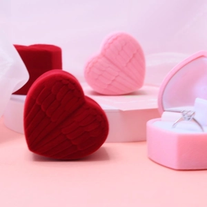 Detail of red and pink heart jewelry boxes with embossed angel wings in soft velvet