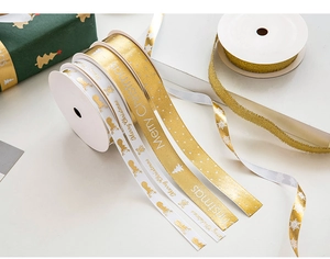 Detail of Merry Christmas gold foil ribbons with reindeer and snowflake patterns