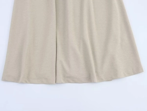 Dettaglio macro della trama del tessuto intrecciato beige e del drappeggio dell'abito