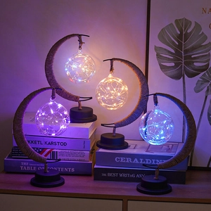 Detail of moon-shaped LED lamps with twine-wrapped metal frames and glass globes