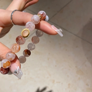 Detailed macro view of natural agate strawberry crystal beads with a gold oval pendant