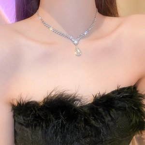 Close-up of a silver Y-shaped tassel necklace with water drop rhinestone pendant on a model