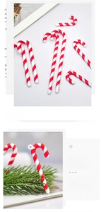 Close-up of red and white candy cane ornaments with spiral pattern on Christmas tree branches