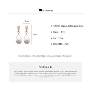 Detail view of water-drop pearl earrings with gold hardware and 3x1cm dimensions